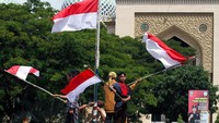 Pemuda mengibarkan bendera Merah Putih setelah merobek bendera Belanda di puncak hotel Yamoto Surabaya saat penampilan drama kolosal siswa SMKN-5 di Lapangan Hiraq Lhokseumawe, Aceh, Sabtu (17/8/2019). Antara Foto/Rahmad.