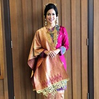 Istri Menteri Sosial Agus Gumiwang Kartasasmita, Loemongga Haoemasan, tampak cantik berbalut baju adat Minang berwarna merah muda lengkap dengan aksesorinya berupa kalung, gelang, dan anting saat menghadiri upacara HUT ke-74 RI di Istana Negara, Sabtu (17/8/2019). Kesan perempuan Minang yang anggun dituangkan dalam busana yang dikenakan oleh Loemongga. Foto: dok. Instagram @didietmaulana