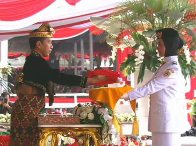 Paskibraka berhijab ini bertugas menerima bendera sang merah putih dari presiden Joko Widodo untuk dikibarkan.   Foto: dok. Youtube, Instagram