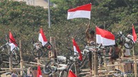 Seorang peserta berhasil mencapai puncak pohon pinang dan mengibarkan bendera Merah-Putih.