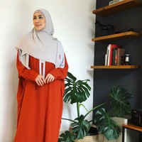 Fenita Arie, istri Arie Untung ini tampak anggun dalam balutan gamis dengan model oversize warna merah dan hijab segi empat dengan model menutupi dada berwarna abu-abu. Foto: dok. Instagram