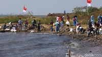 Warga bergotong-royong membersihkan sampah.