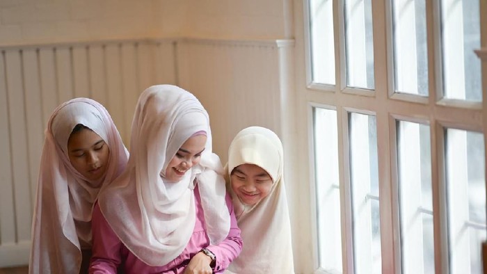 anak berdoa Young Asian Muslim teaching her sister to reading a book