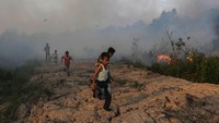 Sejumlah bocah berlari menghindari kebakaran lahan di Desa Kayu Arehh, Kertapati Palembang, Sumatera Selatan, Minggu, (18/8/2019). Antara Foto/Mushaful Umam.