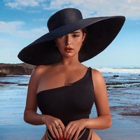 Tak hanya liburan, selama di Bali Demi Rose pun melakukan pemotretan. Beginilah penampilan Demi saat melakukan pemotretan di pantai menggunakan pakaian renang hitam dengan topi pantai.  Foto: Instagram @demirosemawby