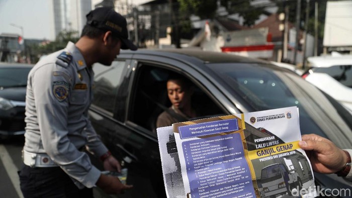 Petugas Dishub dan Polantas melakukan sosialisasi perluasan  ruas jalan ganjil genap di kawasan simpang besar Matraman, Jakarta Timur.