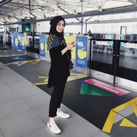 Citra Kirana foto OOTD saat pertama kalinya naik MRT. Citra memakai outfit serba hitam dengan balutan hijab segi empat polos warna hitam yang ia sampirkan ke belakang. Agar penampilan tidak monoton, dia melengkapi penampilannya dengan memakai scarf motif dan sneakers putih. Foto: Instagram