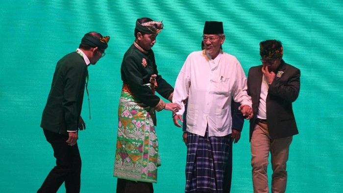 Presiden Joko Widodo (kedua kiri) dan Ketua Umum PKB Muhaimin Iskandar (kanan) menggandeng Ketua Dewan Syuro PKB Dimyati Rois (kedua kanan) disaksikan Sekjen PKB Hanif Dhakiri (kiri) usai membuka Muktamar V PKB di Bali, Selasa (20/8/2019). Muktamar itu mengangkat tema melayani ibu pertiwi. ANTARA FOTO/Akbar Nugroho Gumay/pd.