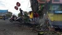 Pascakerusuhan, warga membersihkan sisa ban yang dibakar seusai aksi di Jalan Essau Sesa Manokwari, Papua Barat. Antara Foto/Toyiban.