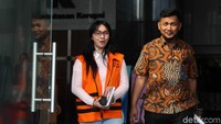 Sri Wahyumi yang mengenakan kemeja putih dibalut dengan sweater berwarna pastel dan rompi oranye KPK nampak mengumbar senyum saat bertemu dengan awak media saat akan meninggalkan gedung KPK.