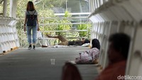 Sedikitnya ada tiga pengemis terlihat tiduran di atas JPO.