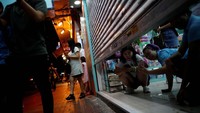 Beberapa perempuan sedang melihat suasana aksi demo besar di Hong Kong. Mereka mengambil gambar suasana demo dalam toko yang sengaja agak ditutup. REUTERS/Kim Hong-Ji.