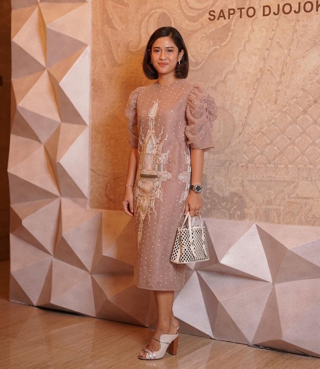 Aktris Dian Sastrowardoyo menebar pesonanya dengan gaun nude motif Candi beraksen kerutan pada bagian lengan dari koleksi Fall/Winter 2019 Sapto. Ia lalu memaksimalkan gayanya dengan handbag putih dan heels senada. Foto: Instagram/@saptodjojokartiko