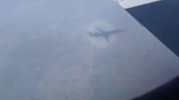 Pelangi yang sebenarnya mengelilingi bayangan pesawat (Foto: Brightside)