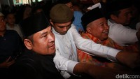Ia terlihat mengenakan koko putih dipadu dengan peci.
