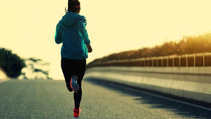 young fitness woman runner running on sunrise road
