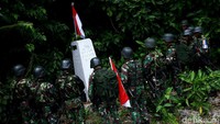 Tiang Sang Saka ditancapkan di patok, Merah Putih berkibar. Para personel Satgas Pamtas membentuk formasi setengah lingkaran menghadap ke patok dan memberi hormat ke Merah Putih.