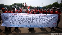 Para buruh membawa spanduk yang berisi penolakan rencana revisi UU Ketenagakerjaan. Pasalnya, revisi itu disebut hanya memprioritaskan kepentingan investasi dan pengusaha daripada nasib buruh.