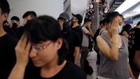 Para demonstran menutup satu mata mereka sebagai bentuk solidaritas terhadap salah seorang demonstran yang disebut terluka dibagian mata akibat kebrutalan pihak kepolisian selama demonstrasi terjadi di Hong Kong. Ann Wang/Reuters.