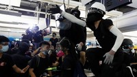 Aksi tersebut kembali bentrok saat para demonstran menyorotkan laser pointer kepada ratusan polisi antihuru-hara yang bersiaga di luar stasiun tersebut. Tyrone Siu/Reuters.