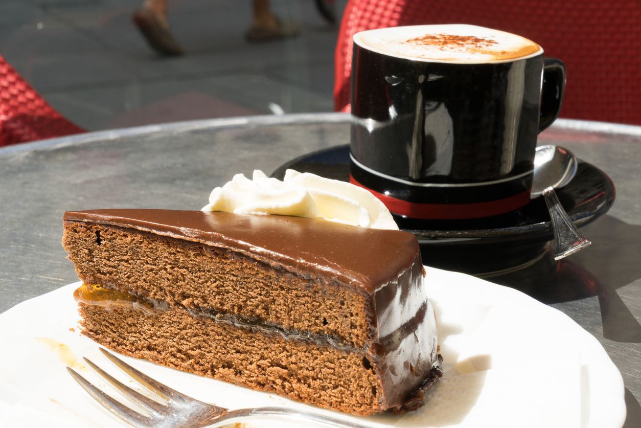 Slice of Sachertorte or Chocolate cake served with fresh cream and coffee