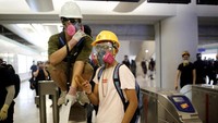 Para demonstran mengenakan masker pelindung dan topi saat menggelar aksi demo di Stasiun Metro Yuen Long, Hong Kong. Ann Wang/Reuters.