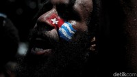Tampak seorang Mahasiswa Papua berhias bendera Bintang Kejora disalah satu sisi wajahnya.