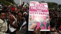 Ada pula peserta aksi yang membawa poster berisi tuntutan agar aparat kepolisian dan TNI ditarik dari Papua Barat.