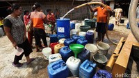 Warga secara bersama-sama datang ke tangki penampungan air sambil membawa jerigen dari rumah.