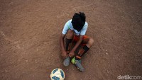 Mereka bermain sepakbola lengkap dengan sepatunya.