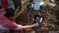 Warga lainnya membantu memberikan air minum saat seorang warga melakukan aksi kubur diri.