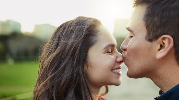 Shot of a young man kissing his girlfriend on the nose outdoors