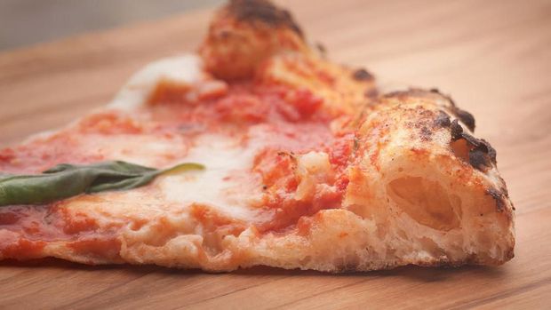 Slice of a perfect pizza margherita: thin disc, thick perfectly leavened crust