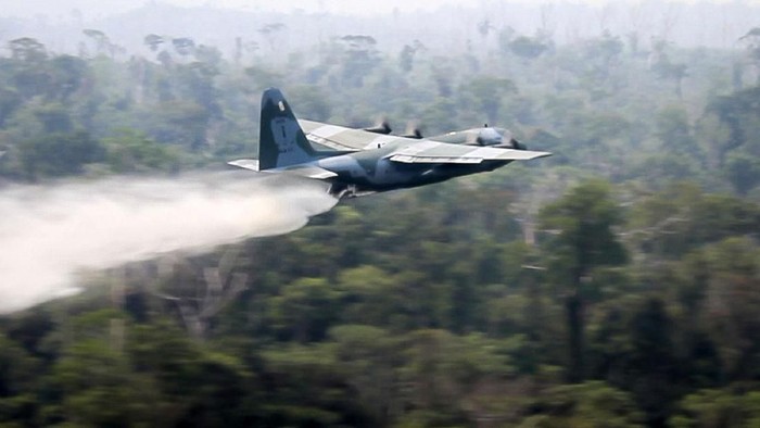 Pesawat dikerahkan untuk membantu memadamkan kebakaran hutan Amazon di Brasil. Pesawat itu mengudara di atas titik api sambil menyemprotkan air.