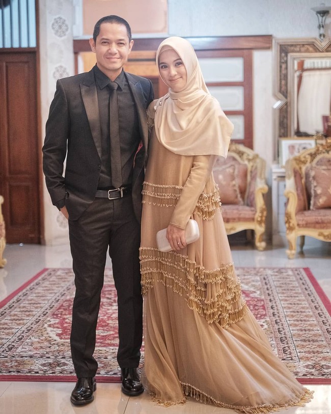 Dress cokelat dengan detail draperi jadi pilihan Alyssa Soebandono yang hadir di resepsi Roger Danuarta dan Cut Meyriska bersama suaminya Dude Herlino. Dress rancangan Khanaan itu dipadukannya dengan jilbab syari berwarna senada. Foto: Instagram