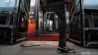 Seorang warga melintas di dalam bus TransJakarta yang telah rusak. 
