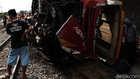 Bus tersebut ringsek dan masih teronggok di pinggir rel kereta.
