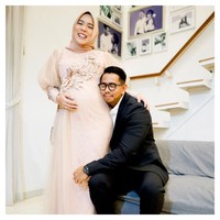 Fitri Tropica yang tengah hamil tampil cantik dalam balutan dress Ayu Dyah Andari. Dress tampil mewah dengan detail bunga yang memanjang di bagian dada. Dress dengan lengan terompet ini cocok untuk membuat tampilan wanita hamil tetap elegan saat pesta. Foto: Instagram