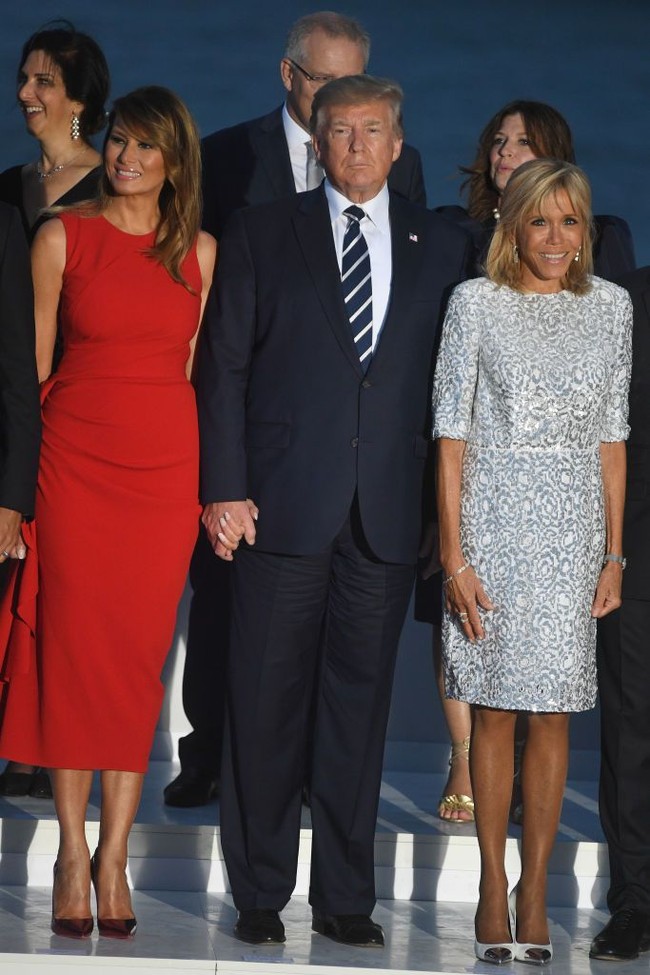 Turut hadir di kesempatan tersebut, Ibu Negara Prancis Brigitte Macron. Ia tampil dengan mini-dress putih bermotif abstrak dan heels senada. (Foto: Getty Images)