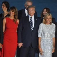 Turut hadir di kesempatan tersebut, Ibu Negara Prancis Brigitte Macron. Ia tampil dengan mini-dress putih bermotif abstrak dan heels senada. (Foto: Getty Images)