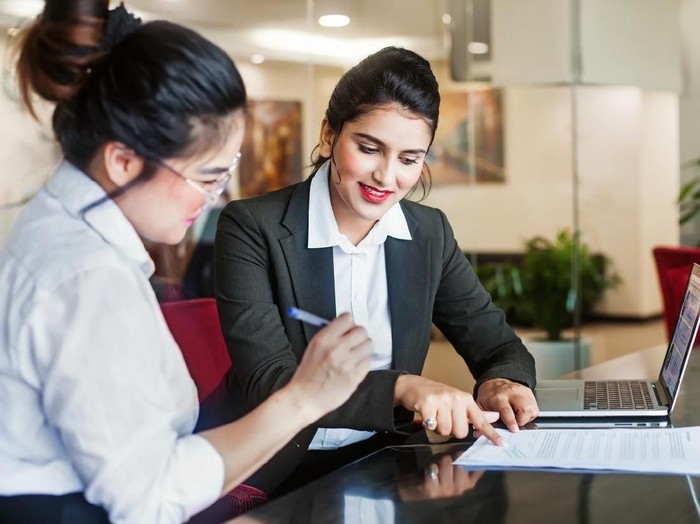 Indian female agent helping client sign the application document
