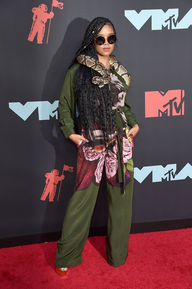 Jumpsuit Valentino menjadi pilihan H.E.R. Namun, aksesori berupa ular hidup yang membuat gaya pelantun Focus itu kian mencuri perhatian.  (Foto: Jamie McCarthy/Getty Images)