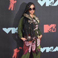 Jumpsuit Valentino menjadi pilihan H.E.R. Namun, aksesori berupa ular hidup yang membuat gaya pelantun Focus itu kian mencuri perhatian.  (Foto: Jamie McCarthy/Getty Images)