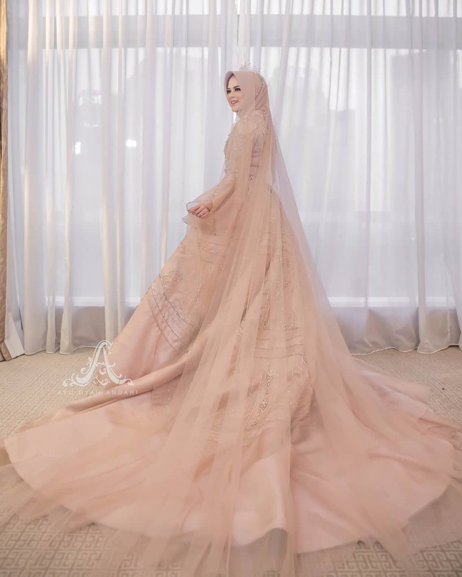 Cut Meyriska berpose membelakangi kamera memperlihatkan bagian belakang gaunnya yang dramatis. Gaun yang panjangnya menyapu lantai itu juga dilengkapi veil yang panjang. Foto: Instagram @dierabachirInstagram @byayudyahandar