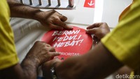 Laode dan William tampak memasang stiker Berani Jujur Hebat di dinding gerbong MRT.