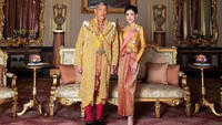 Dalam foto ini, Sineenat tampak memakai pakaian tradisional Thailand dan berdiri di sebelah Raja Vajiralongkorn. Keduanya tampak bergandengan tangan dalam foto ini. Foto: HANDOUT/AFP/Getty Images