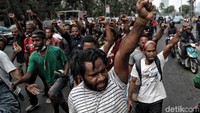 Para mahasiswa asal Papua berorasi sambil mengepalkan tangan.