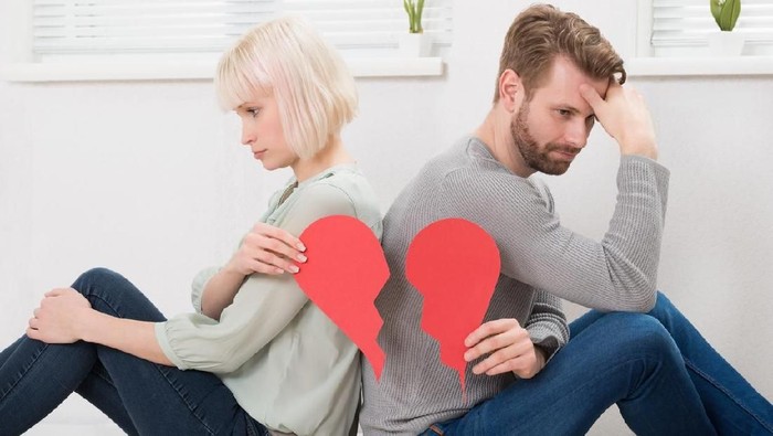 pasangan putus cinta Sad Couple Sitting Back To Back Holding Red Broken Heart