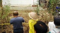 Warga hanya bisa menyaksikan rekonstruksi dari kejauhan karena sekitar lokasi telah dipasangi garis polisi.