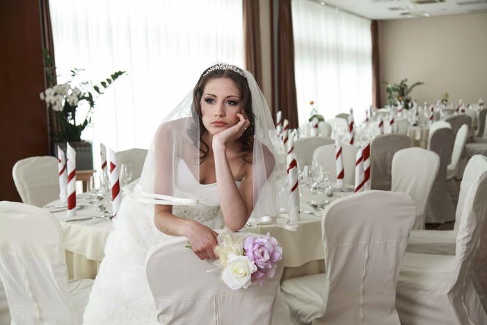 ilustrasi pengantin sedih Bride sitting in a ceremony waiting restaurant. Sitting sad with head and flowers in her hands.